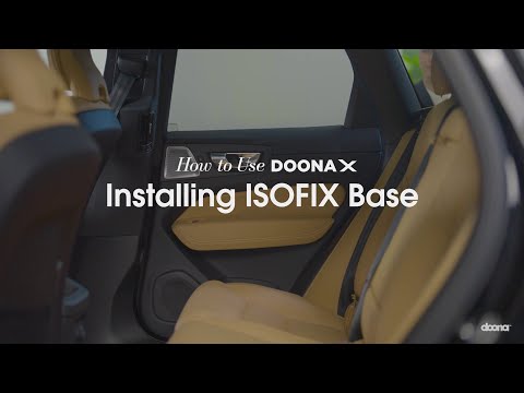Doona ISOFIX Basis voor de Doona X autostoel, geïnstalleerd in een auto met kleurindicatoren voor veilige bevestiging.