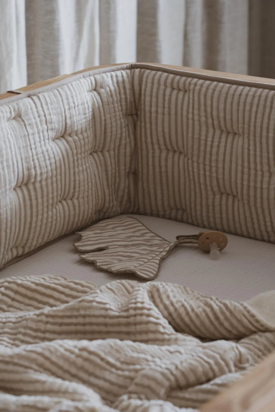 Quax Omrander Bed/Park Natural Stripes, gemaakt van zachte muslin katoen, met touwtjes voor veilige bevestiging.
