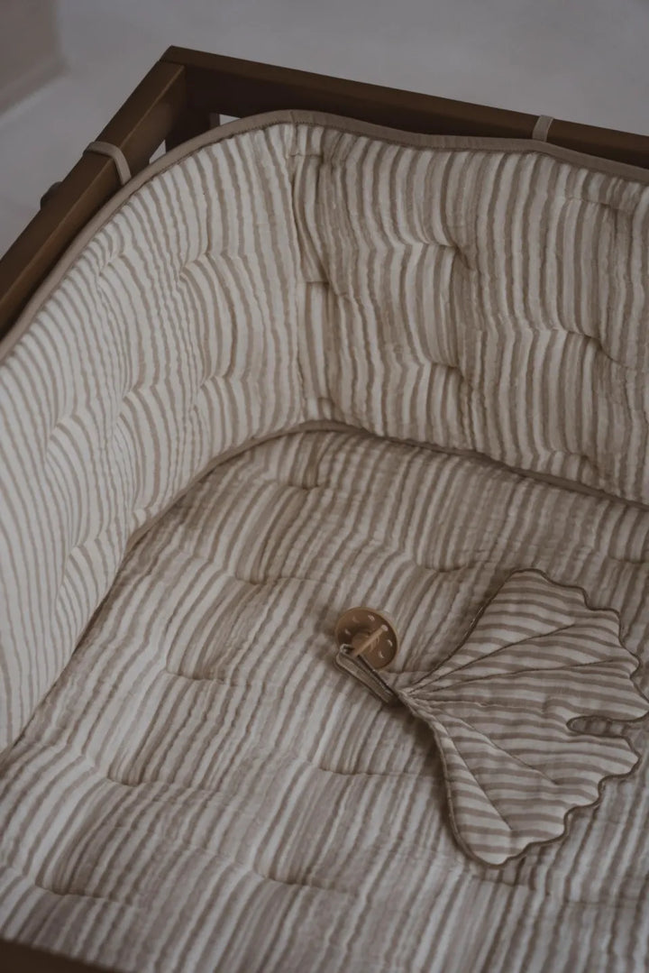 Quax Omrander Bed/Park Natural Stripes, gemaakt van zachte muslin katoen, met touwtjes voor veilige bevestiging.
