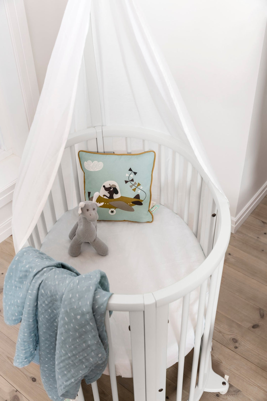 Stokke Sleepi™ V3 piekstok in white finish, bevestigd aan een kinderbed, klaar voor het ophangen van een bedhemeltje