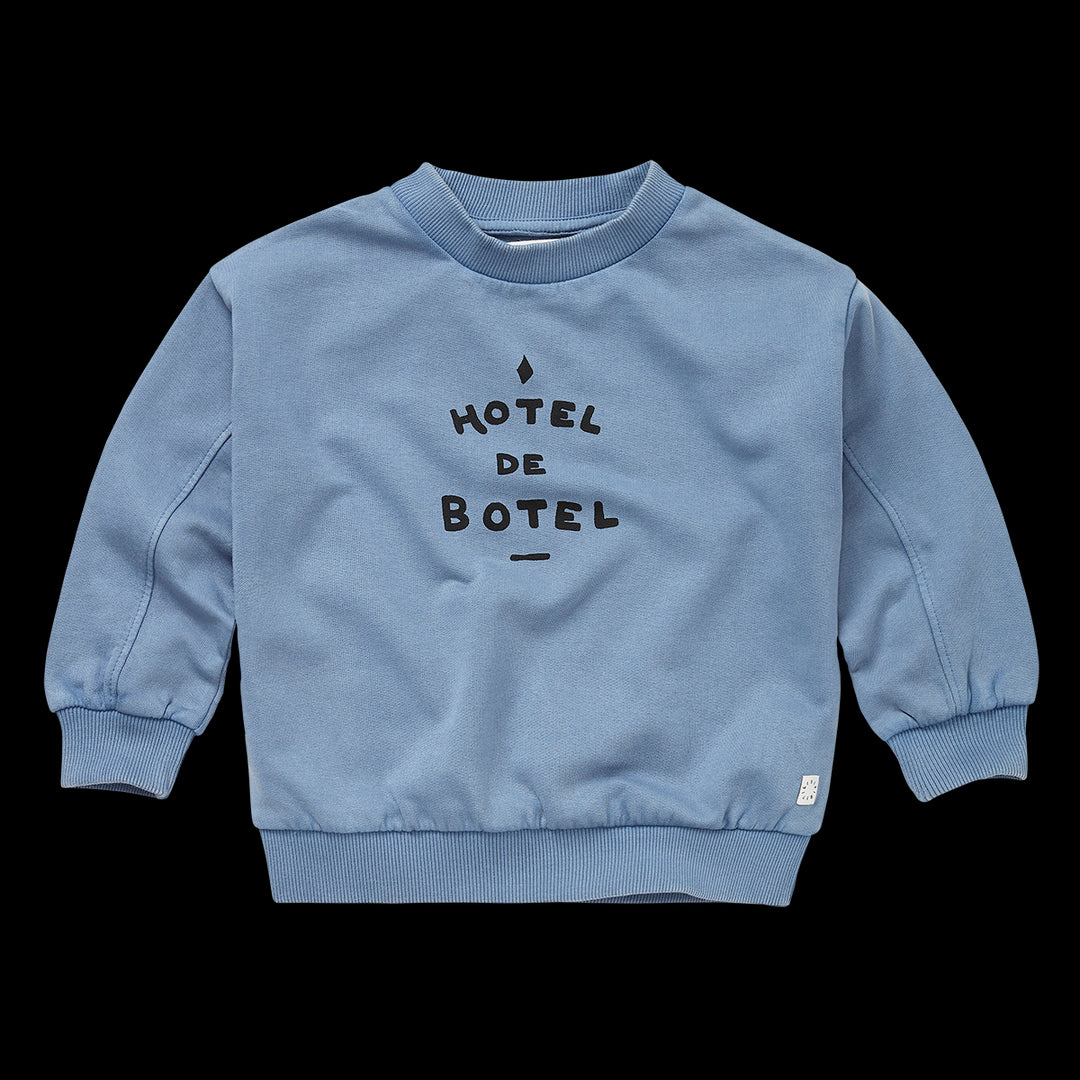 Sproet & Sprout blauwgrijze sweater met Hotel De Botel opschrift, gemaakt van extra zacht biologisch katoen