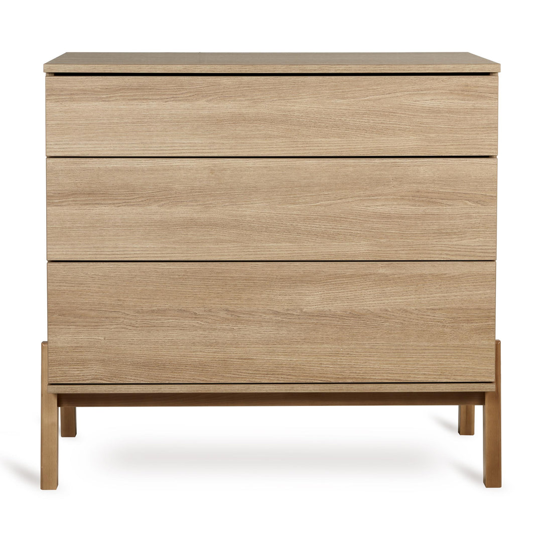 Quax Ashi Commode in Honey Ash met drie push-open laden en optionele luiertafel-extensie voor stijlvolle en praktische kinderkameropslagsh