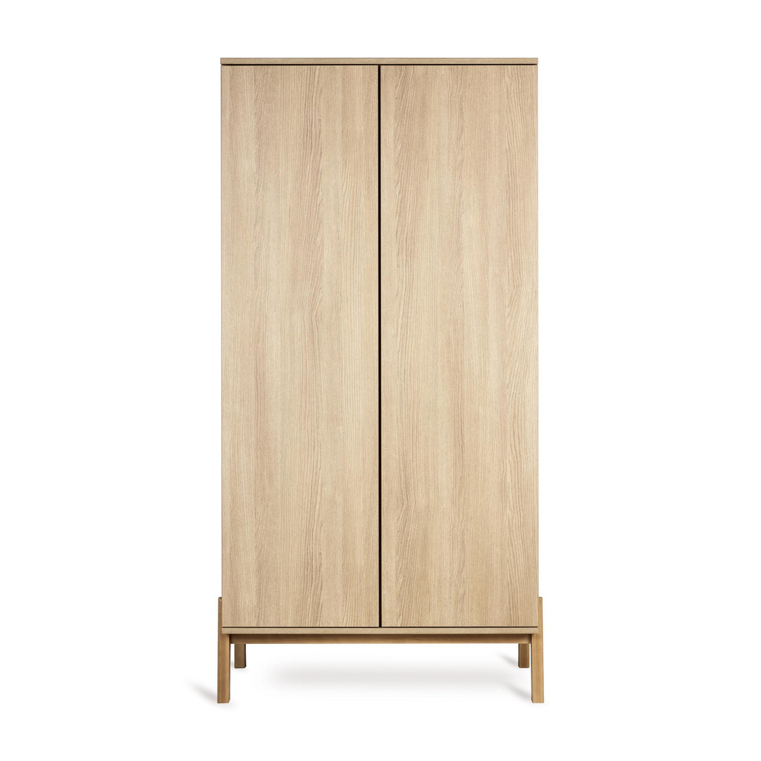 Quax Ashi Kast in Honey Ash met subtiele push-open deuren en aanpasbare opbergruimte, perfect voor de moderne babykamer