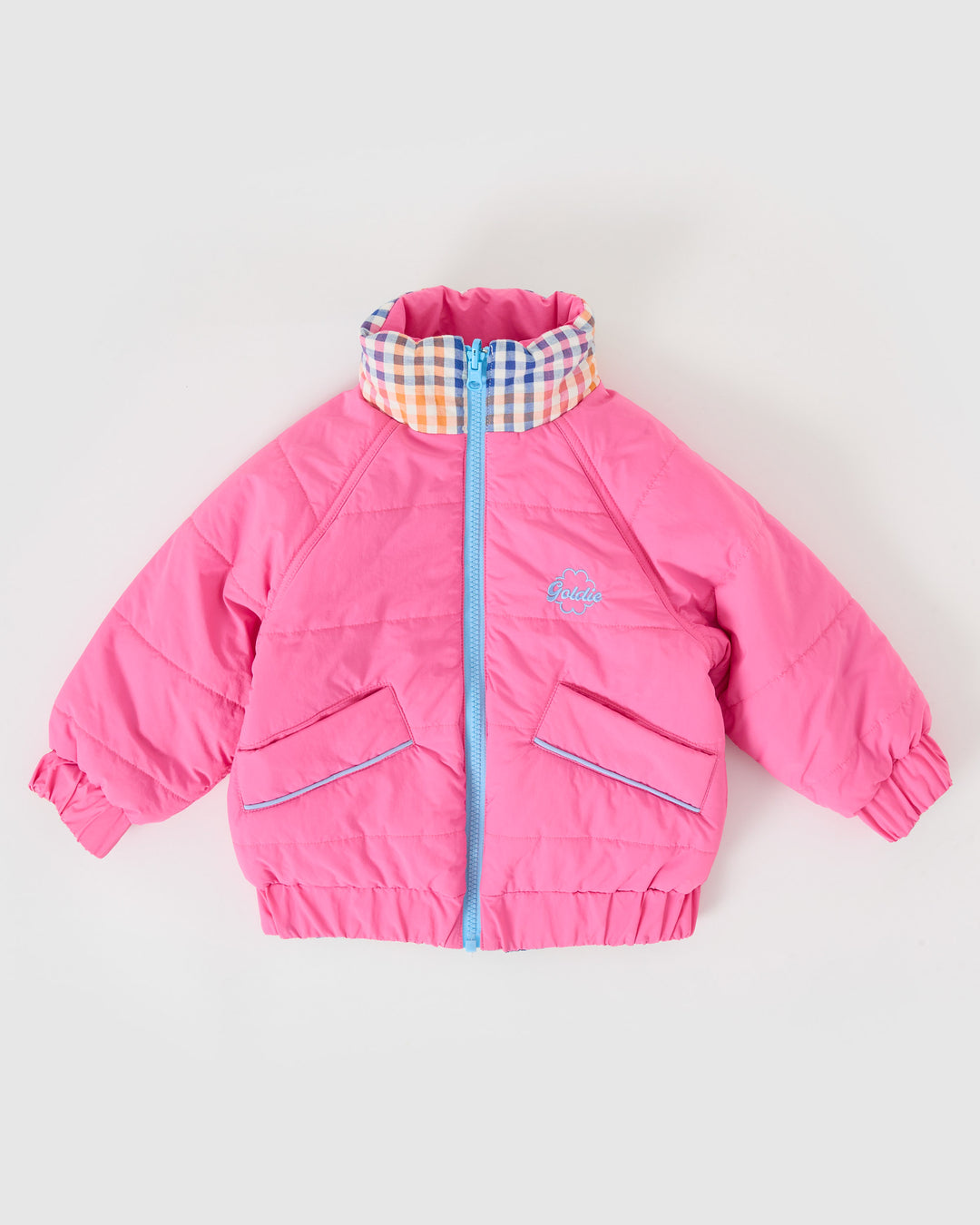 Kind draagt omkeerbare roze pufferjas met regenboogruit van Goldie + Ace