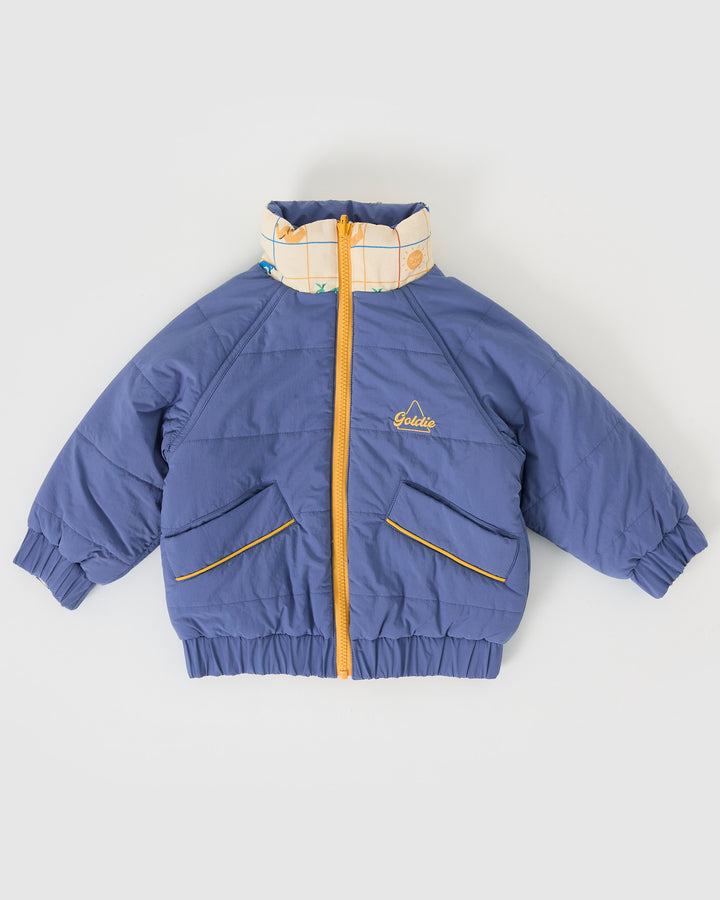 Kind draagt omkeerbare blauwe pufferjas met kangoeroeprint van Goldie + Ace