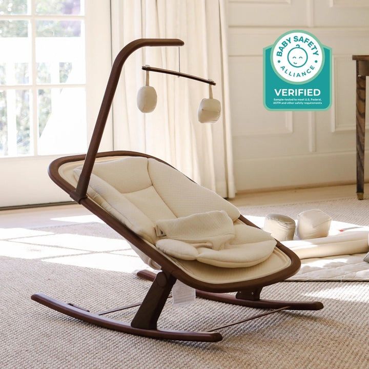 Snuggle Me Relax babywipstoel in walnoot met biologisch katoenen bekleding en speelgoedboog.