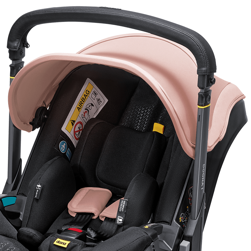 Doona i autostoel in Blush Pink, transformeert van autostoel naar vervoersmiddel met wielen, voldoet aan i-Size normen.