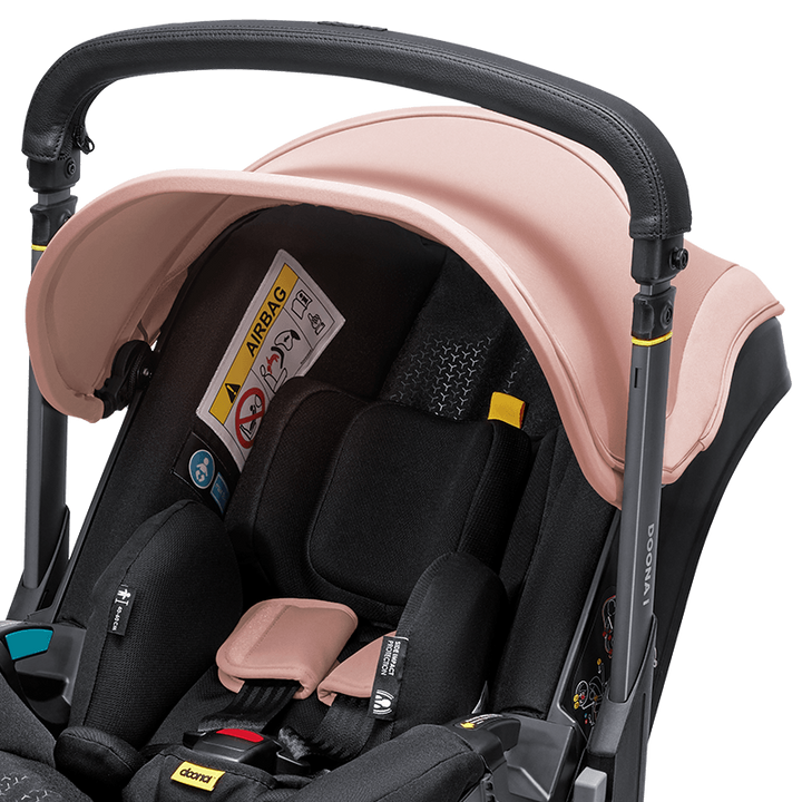 Doona i autostoel in Blush Pink, transformeert van autostoel naar vervoersmiddel met wielen, voldoet aan i-Size normen.