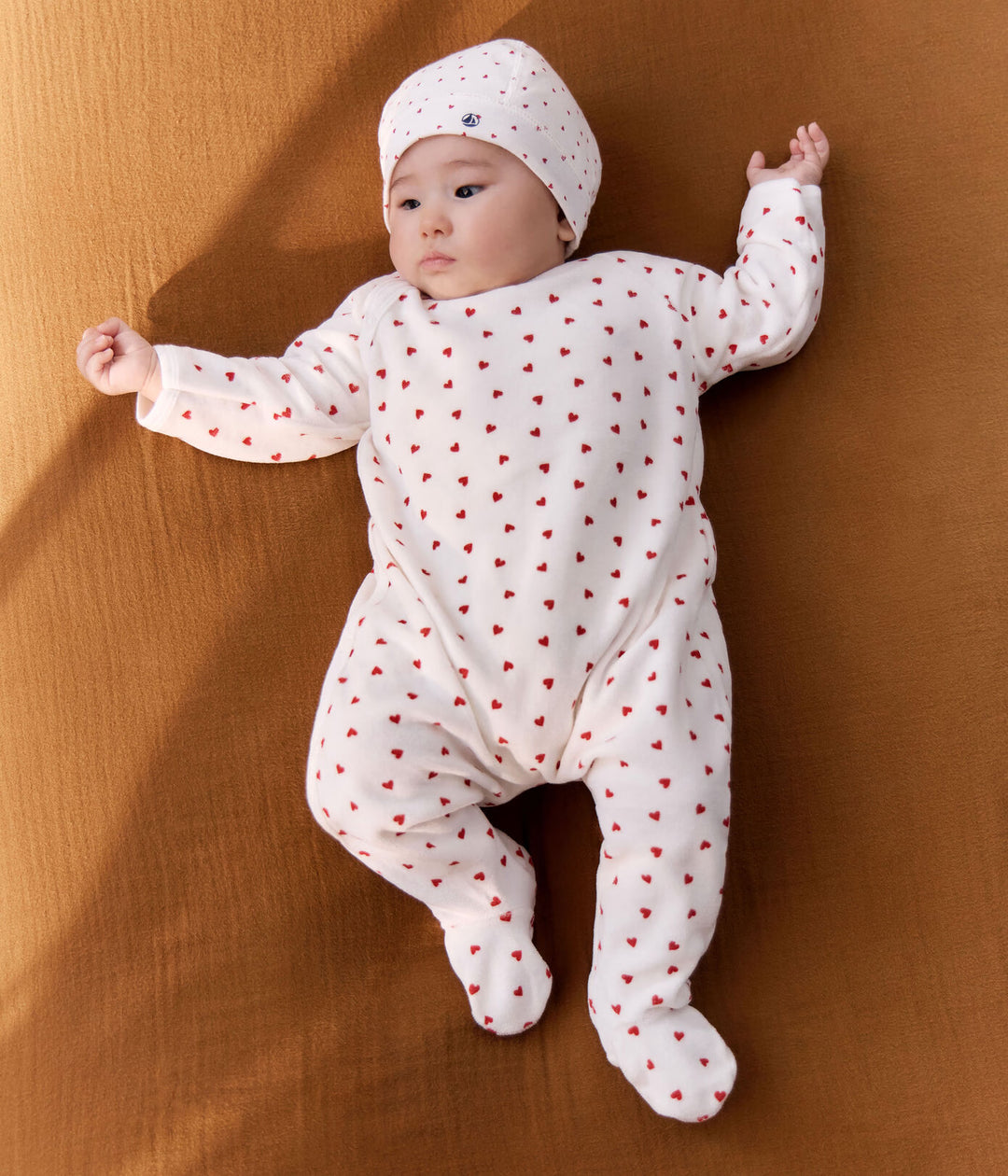 Petit Bateau baby pyjama met rode hartjes en zijsgewijze sluiting