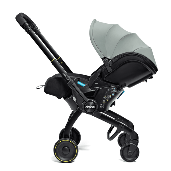Doona X autostoel in Dusty Sage, omgevormd tot kinderwagen met verstelbare hoofdsteun en faux-leather handgreep.