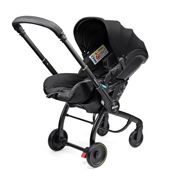 Doona X autostoel in Nitro Black, omgevormd tot kinderwagen met verstelbare hoofdsteun en faux-leather handgreep.