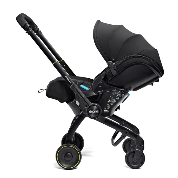 Doona X autostoel in Nitro Black, omgevormd tot kinderwagen met verstelbare hoofdsteun en faux-leather handgreep.