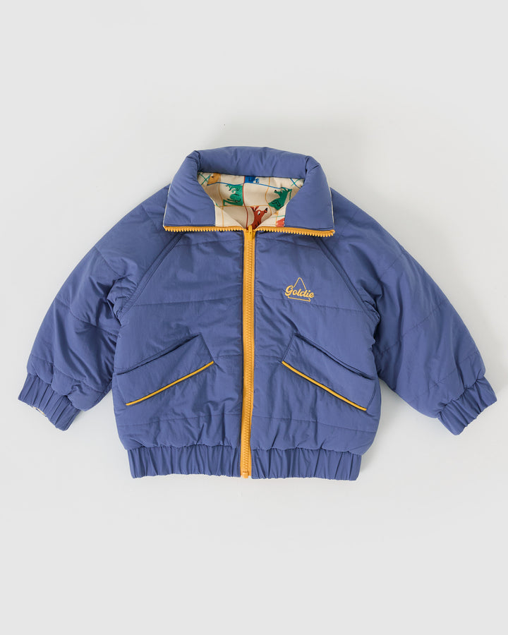 Kind draagt omkeerbare blauwe pufferjas met kangoeroeprint van Goldie + Ace