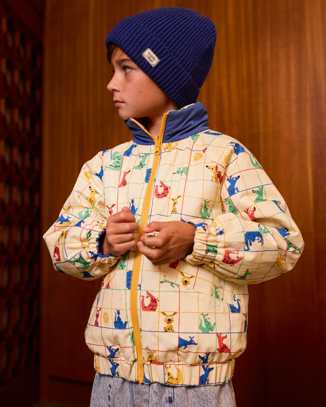Kind draagt omkeerbare blauwe pufferjas met kangoeroeprint van Goldie + Ace