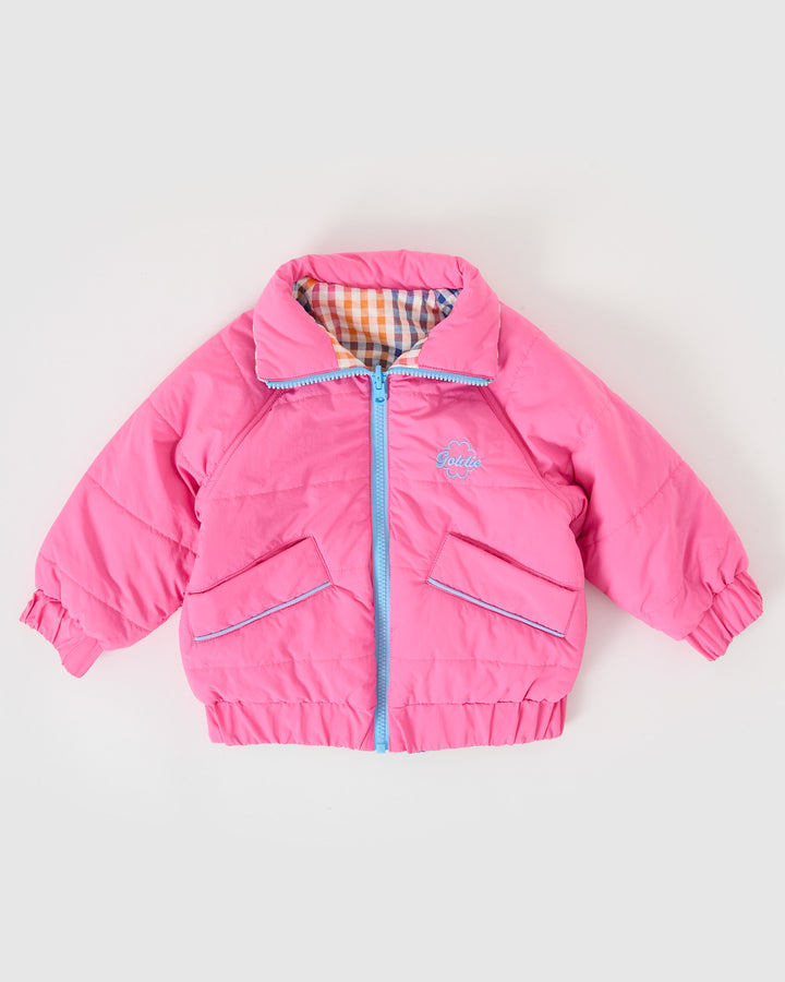Kind draagt omkeerbare roze pufferjas met regenboogruit van Goldie + Ace