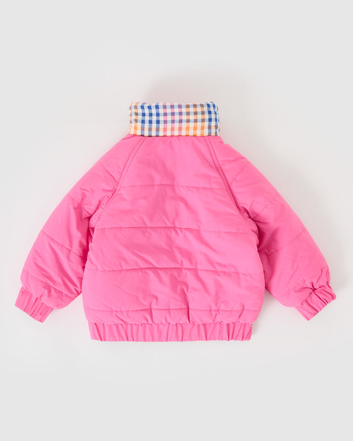Kind draagt omkeerbare roze pufferjas met regenboogruit van Goldie + Ace