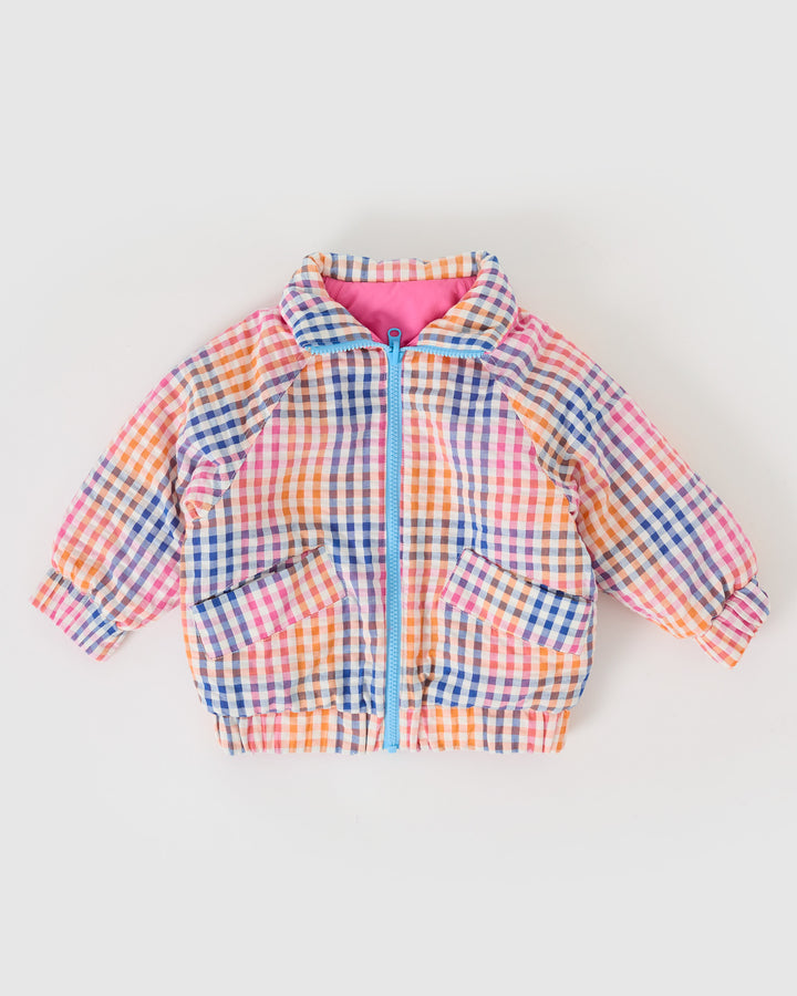 Kind draagt omkeerbare roze pufferjas met regenboogruit van Goldie + Ace