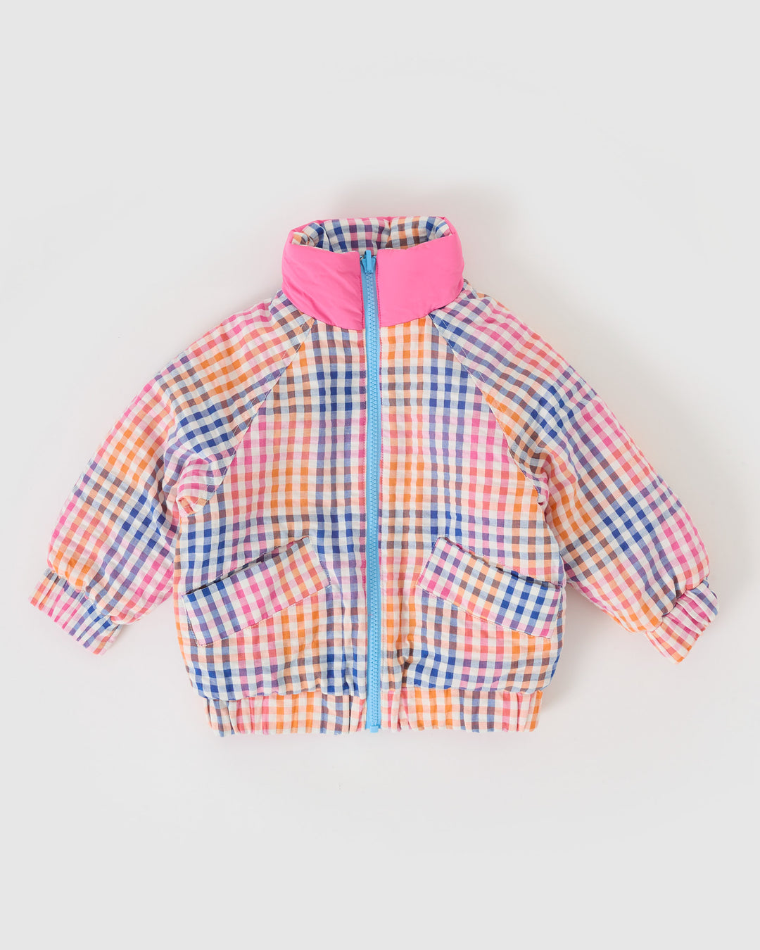Kind draagt omkeerbare roze pufferjas met regenboogruit van Goldie + Ace
