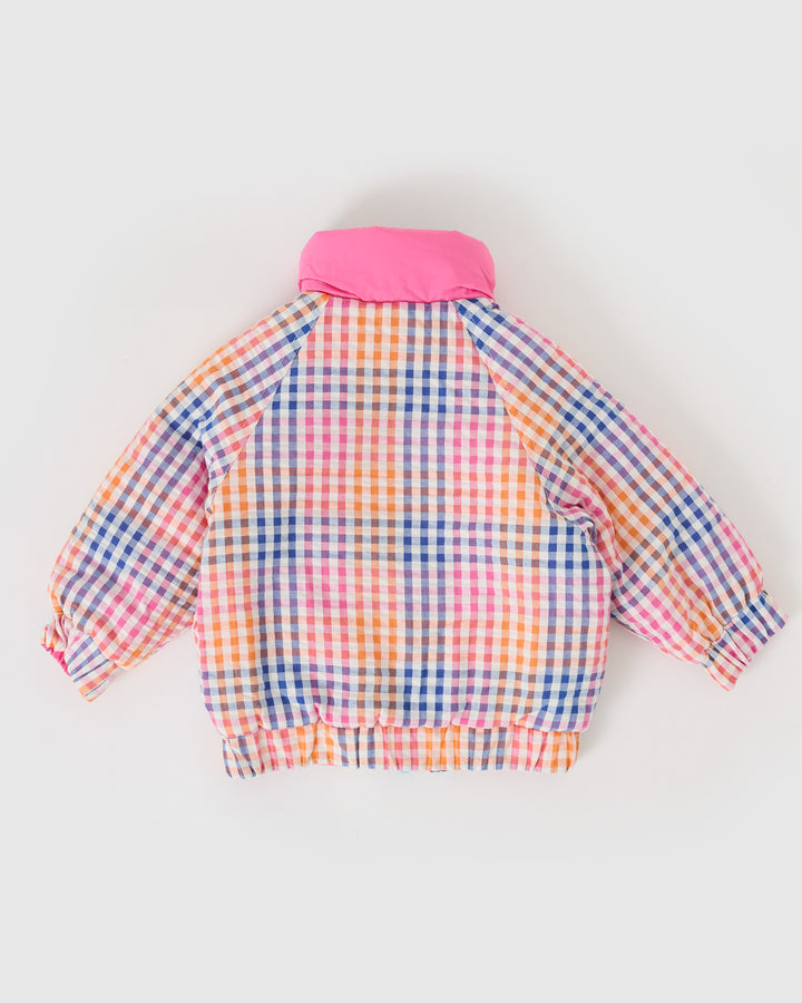 Kind draagt omkeerbare roze pufferjas met regenboogruit van Goldie + Ace