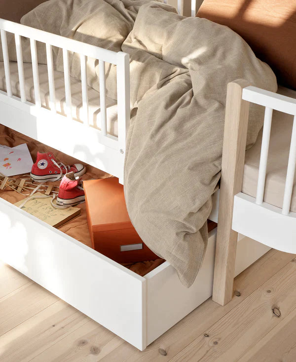 Witte opberglade van Oliver Furniture, geplaatst onder een bed, toont praktische opbergruimte in een minimalistische kinderkamer.