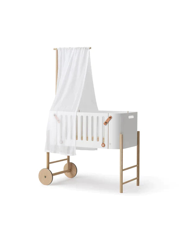 Staander van massief eikenhout voor hemel of mobiel, toegevoegd aan een co-sleeper in een stijlvolle babykamer.
