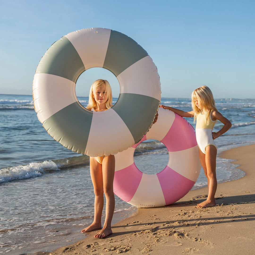 Groen-wit gestreepte zwemband van Sunnylife drijvend op helder water
