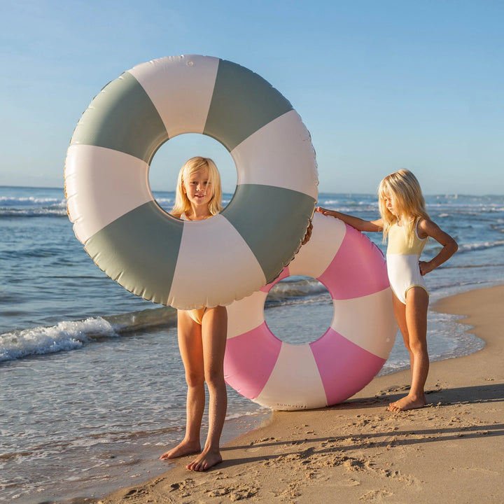 Groen-wit gestreepte zwemband van Sunnylife drijvend op helder water