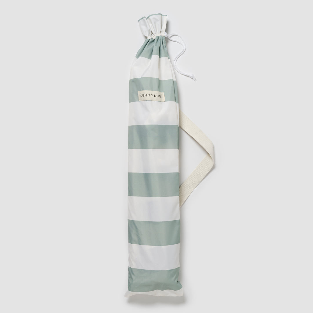 Sunnylife Parasol Compact La Palma in groen-wit gestreept design op het strand