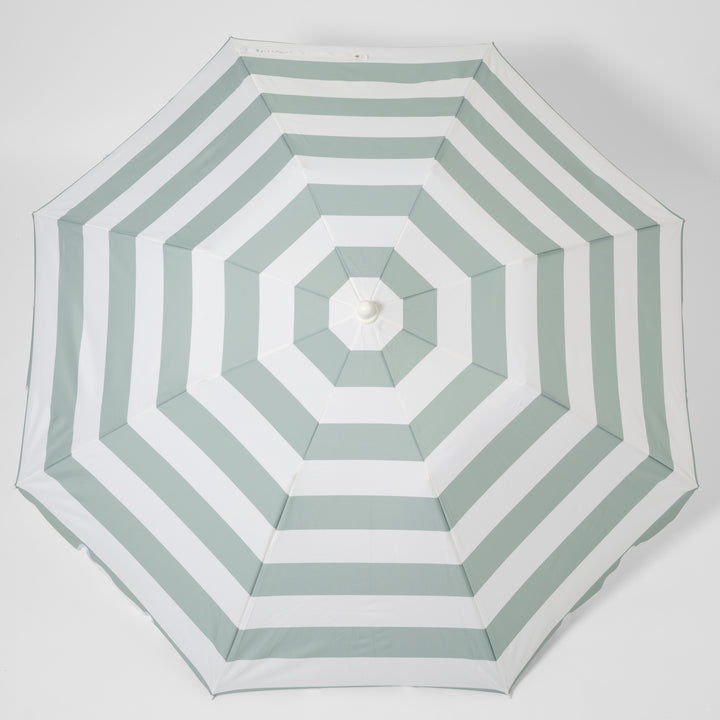 Sunnylife Parasol Compact La Palma in groen-wit gestreept design op het strand