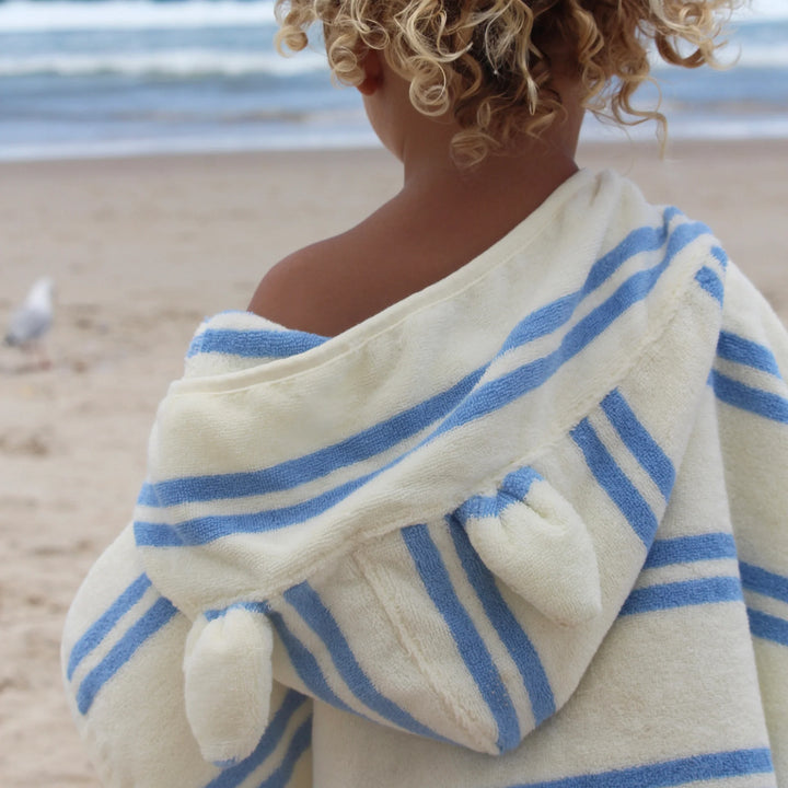 Kinderponcho met blauwe strepen en zachte badstof van Sunnylife, model Sid the Seagull