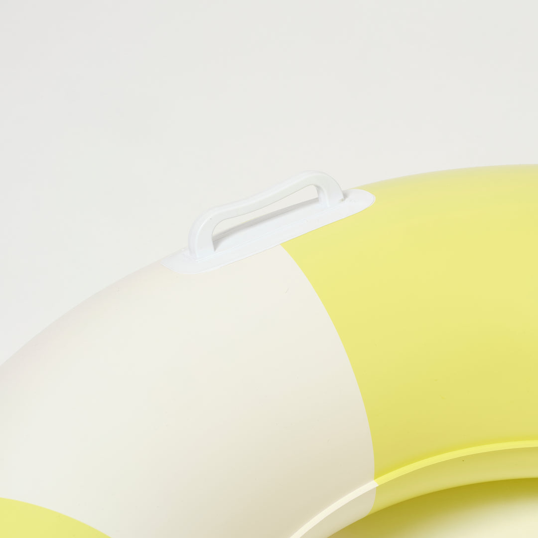 Slanke zwemband met gele strepen van Sunnylife, drijvend in helder zwembadwater
