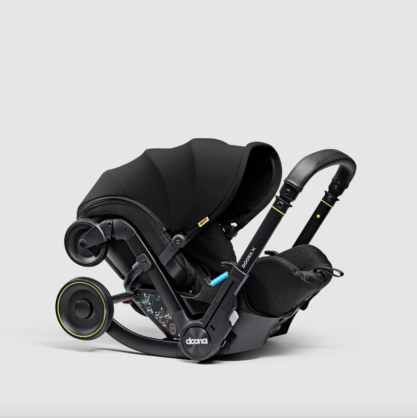 Doona X autostoel in Nitro Black, omgevormd tot kinderwagen met verstelbare hoofdsteun en faux-leather handgreep.