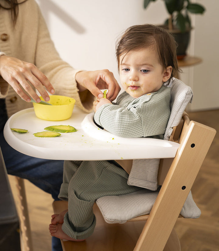 Stokke Tripp Trapp eettablet in Storm Grey, bevestigd aan een Baby Set voor kinderen