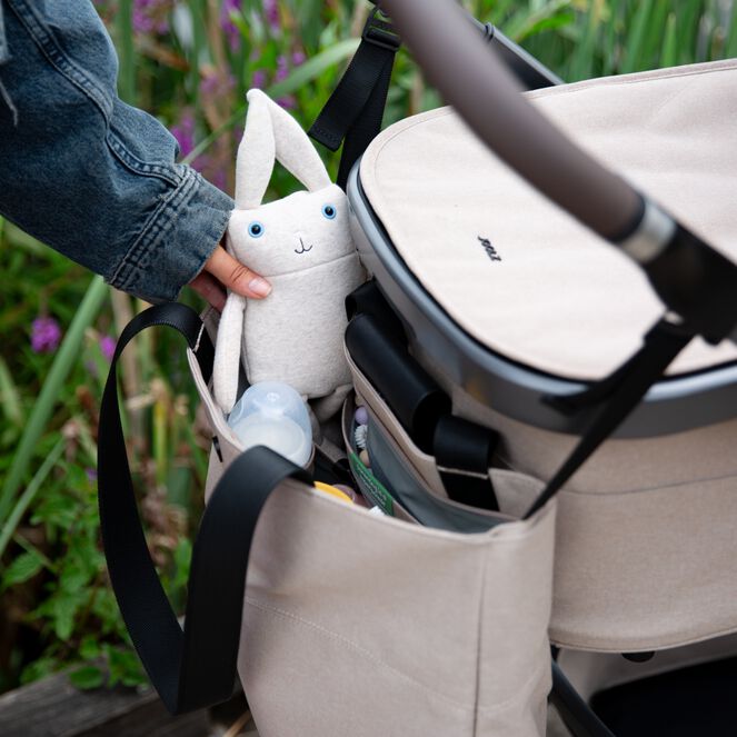 Joolz Verzorgingstas in Sandy Taupe, bevestigd aan kinderwagen.