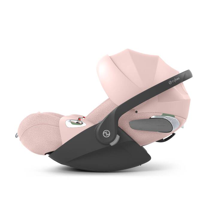Cybex Cloud T i-Size baby-autostoel in peach pink, getoond in liggende positie met ISOFIX basis.