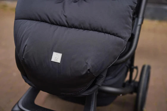 Voetenzak Puffed Black van Jollein voor kinderwagen of buggy, met openingen voor 3- en 5-puntsgordels en waterafstotend polyester