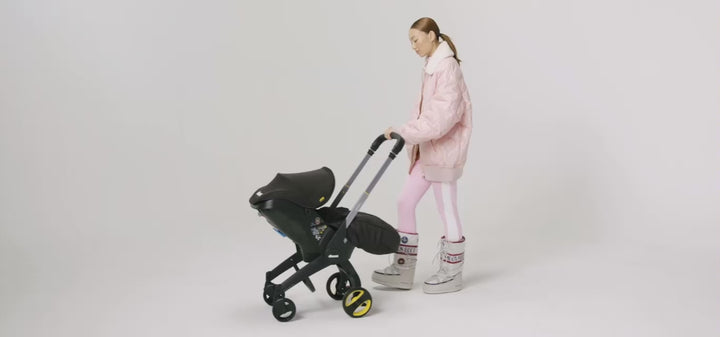Doona i autostoel in Blush Pink, transformeert van autostoel naar vervoersmiddel met wielen, voldoet aan i-Size normen.