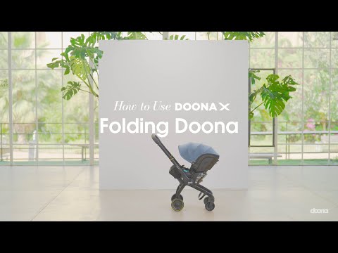 Doona X autostoel in Dusty Sage, omgevormd tot kinderwagen met verstelbare hoofdsteun en faux-leather handgreep.